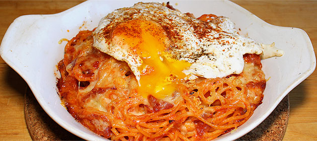 Gratinierte Tomatenspaghetti mit Zwiebel, Käse, Knoblauchbutter und Spiegelei