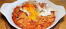 Gratinierte Tomatenspaghetti mit Zwiebel, Käse, Knoblauchbutter und Spiegelei